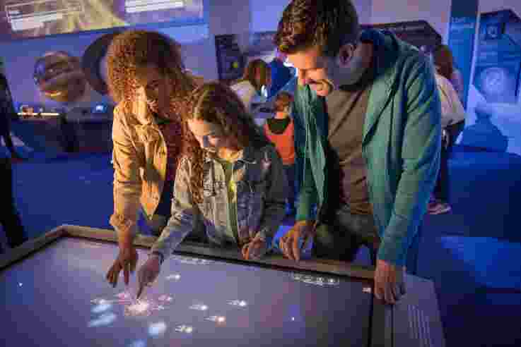 Family using the interactive display at Armagh Planetarium