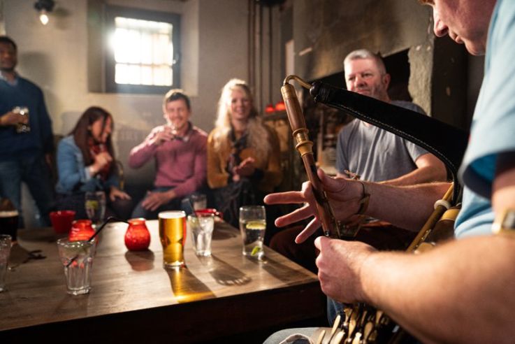 Friends enjoying Belfast's Traditional Music Trail, and learning to Irish dance at McHugh's Bar and Restaurant as part of the Embrace a Giant Spirit experience.