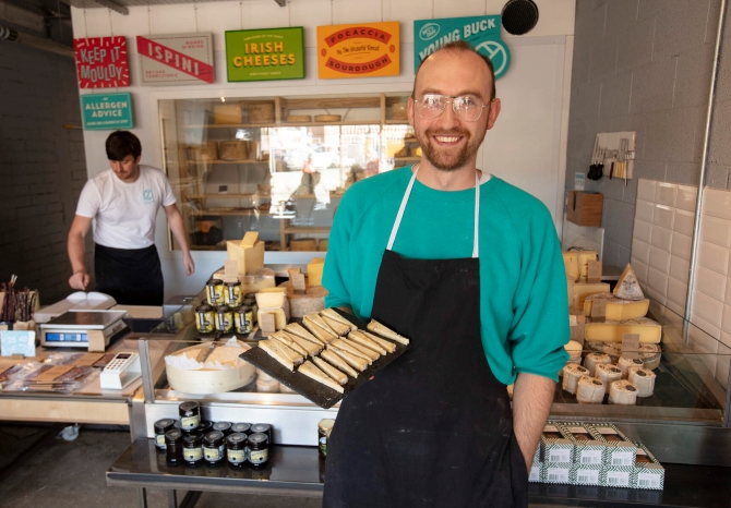 Michael Thompson, owner of Young Buck Cheese displaying his home-made goods as part of the Belfast Food Tour experience.
