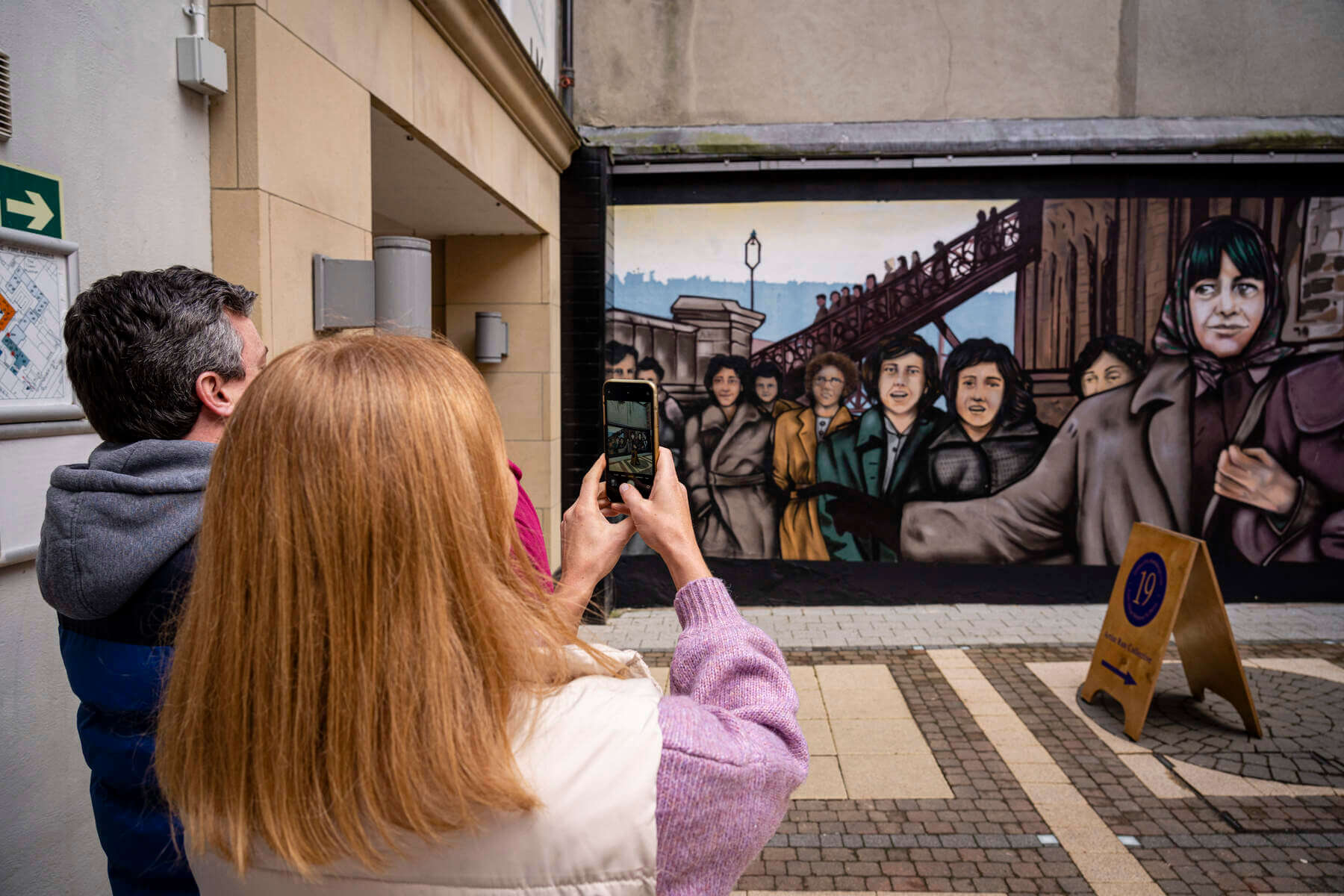 Couple taking photo of murals in Derry Londonderry