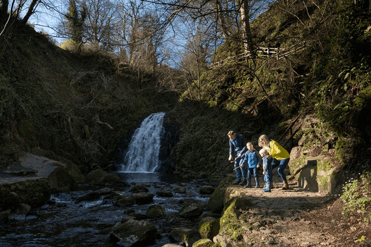 Family admiring Glenoe Waterfall