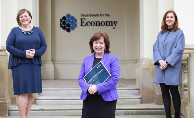 Three women pictured outside on stairs, socially distanced and smiling at the camera.