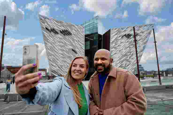 Couple taking a photograph together outside Titanic Belfast