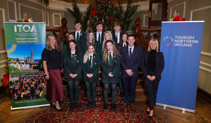 Students and staff gathered together behind ITOA and TNI signage, smiling and engaging in conversation.