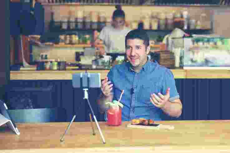 Social media influencer or food blogger creating content inside small restaurant 